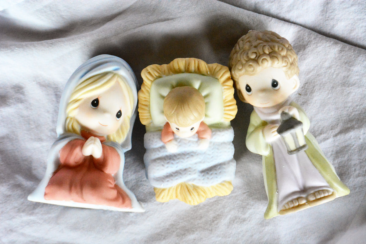 Precious moments nativity scene display. Mary and Joseph side by side and Jesus in a manger on a natural background. 